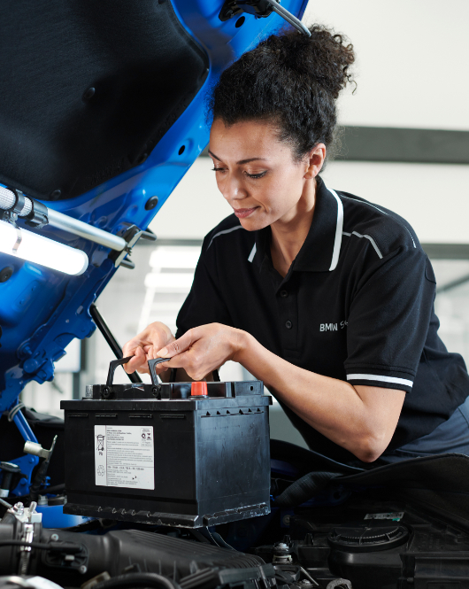 BMW Trained Technician installs a battery on a BMW vehicle in a BMW Service Center.